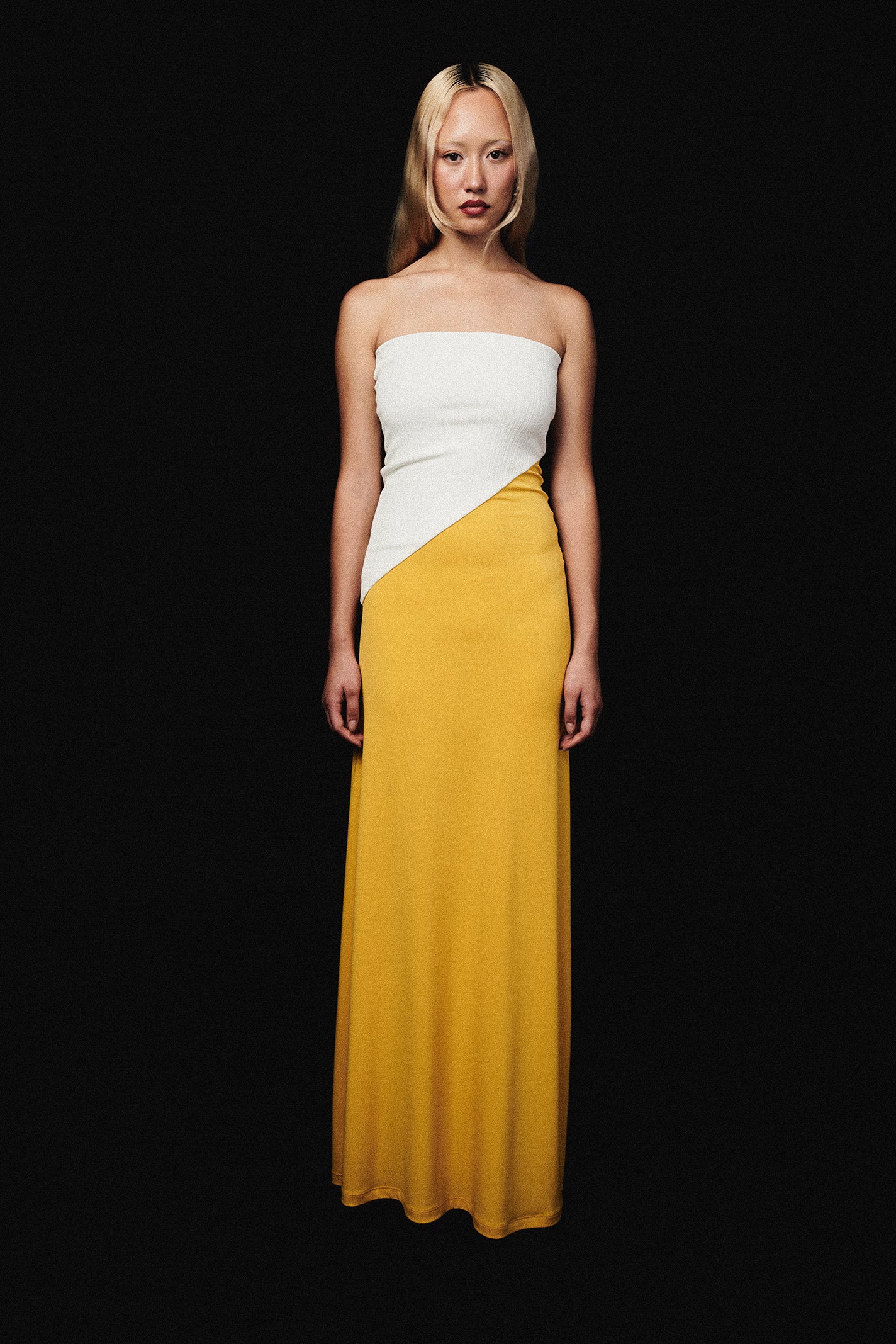 Woman in strapless maxi dress with white top and yellow skirt.