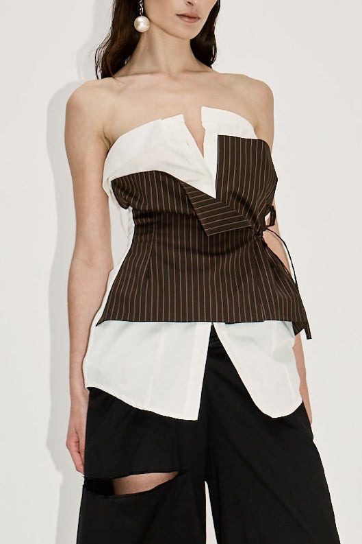 Woman in white strapless top with elements of traditional shirting. Layered brown stripe asymmetric tie front detail. Deconstructed look.