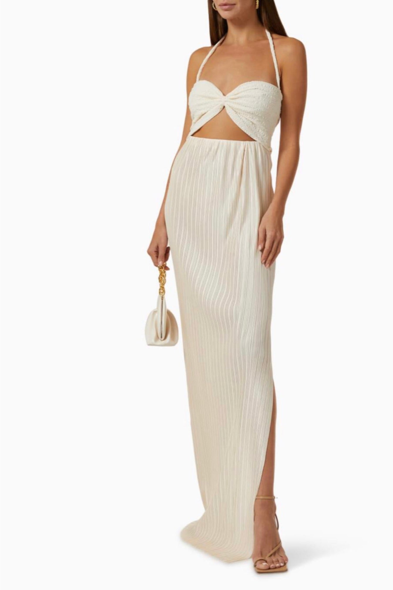 Woman in white halter neck maxi dress. Featuring side slits and soft pleating in the skirt and cut out and cinched bust detail on the top. Perfect for vacation.