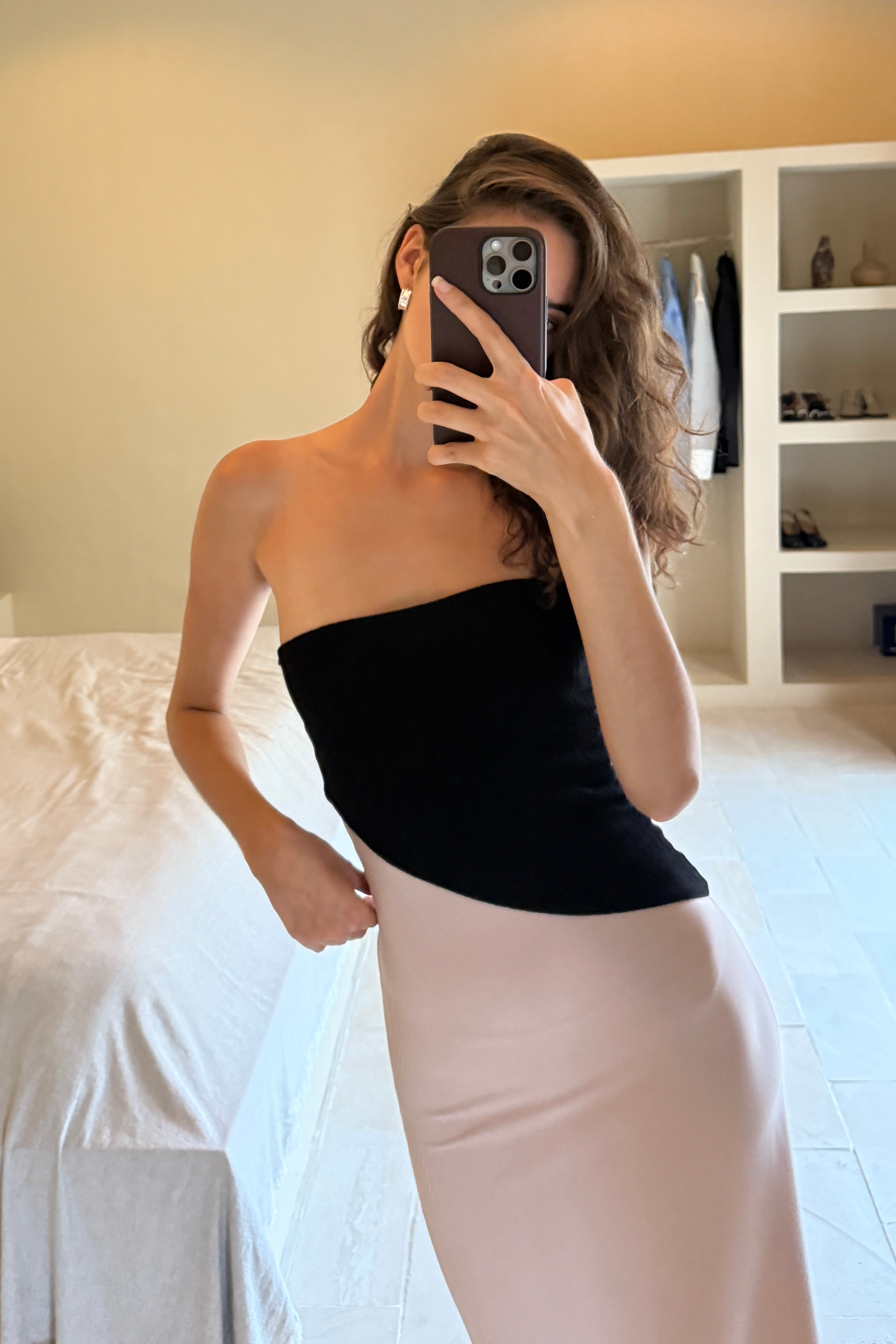 Woman in strapless maxi dress with black asymmetric top and blush skirt. Perfect for Summer/Vacation.