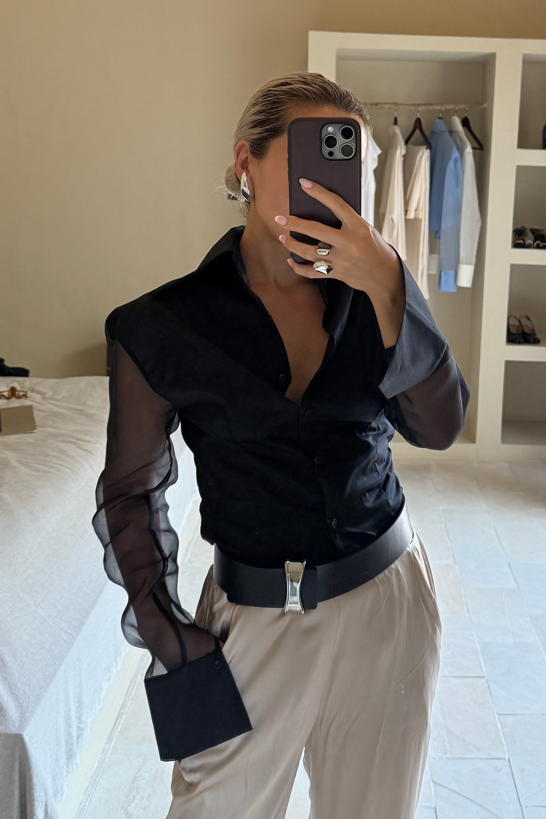 Black button down shirt with silk organza sheer sleeves. Styled buttoned up with beige pants. Perfect for the office or summer outings.