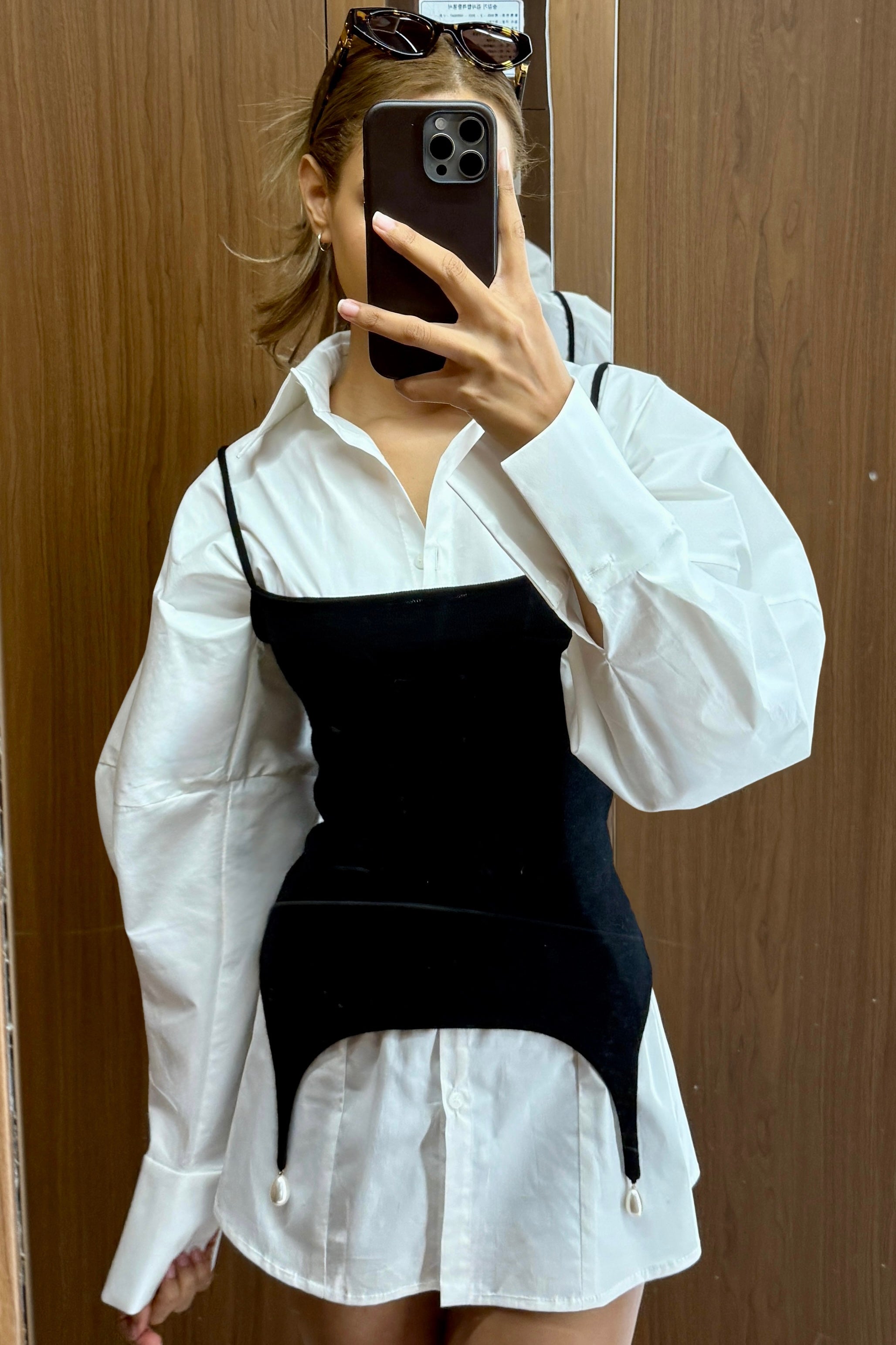 White volume sleeve shirt dress with form fitting black tank with pearl hem detail on top.