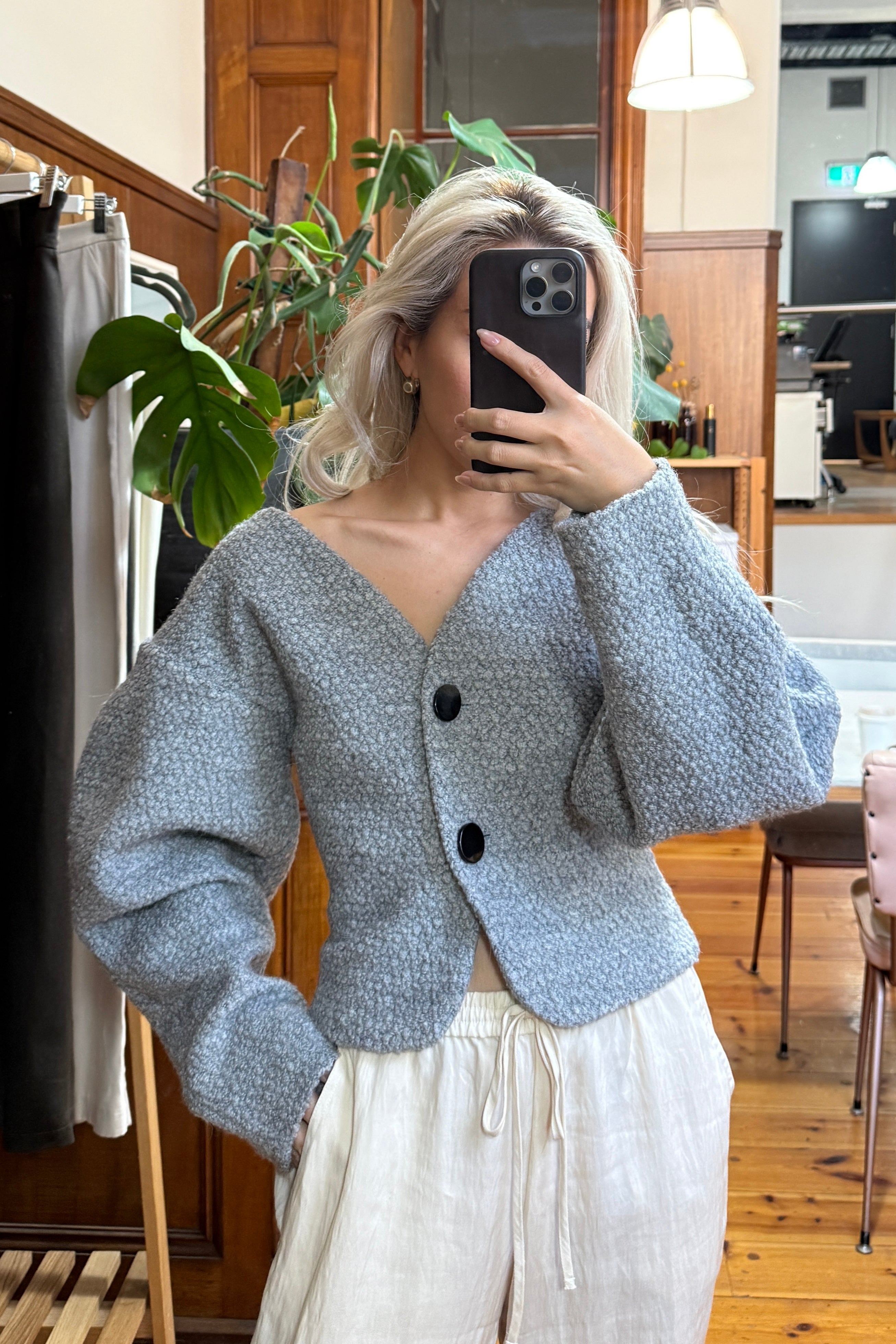 Grey bouclé cardigan with voluminous sleeves. Paired with cream linen pants. Officewear essential.
