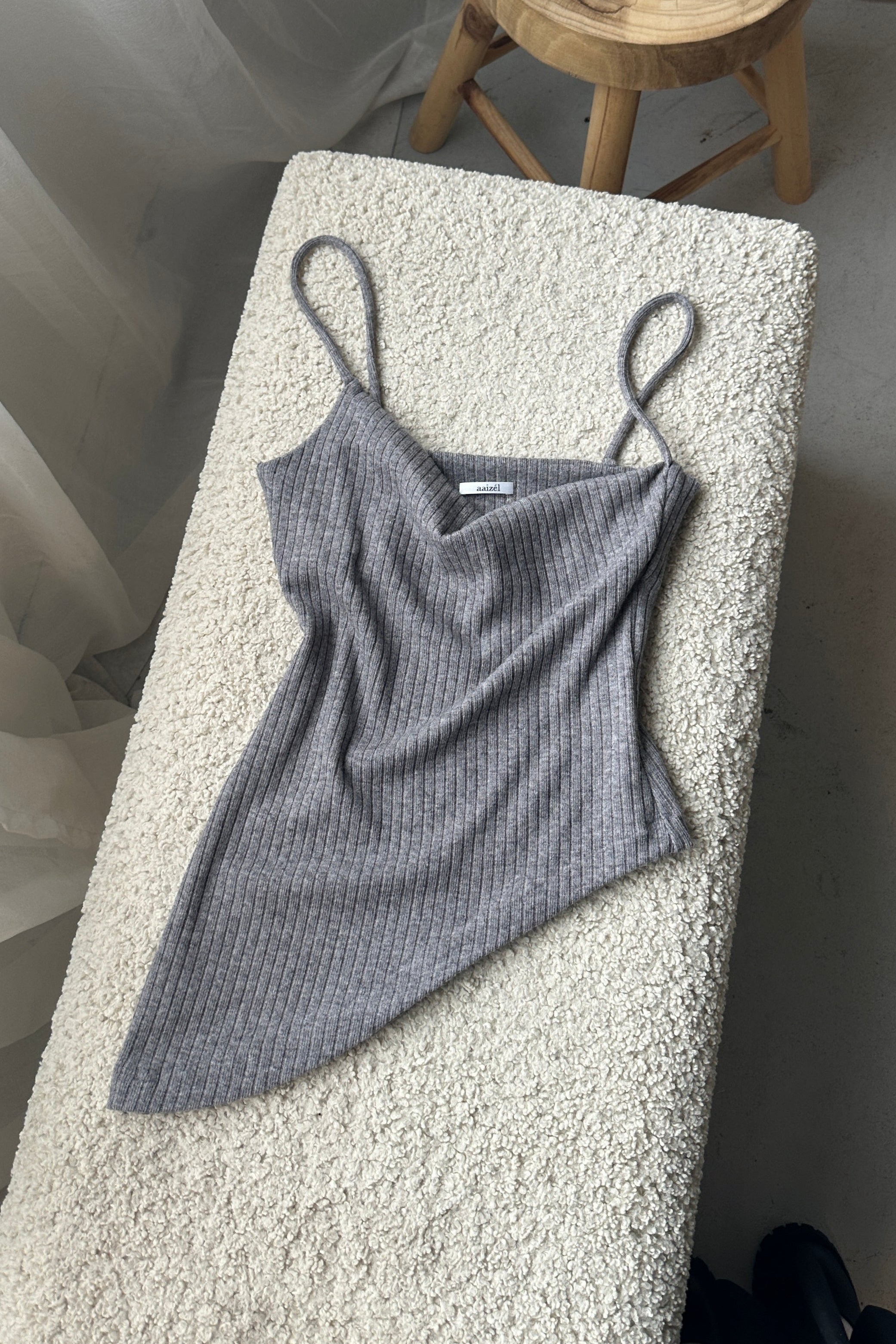 Flat lay of grey loungewear top. Cowl neck, spaghetti straps and asymmetric hem. Crafted from soft rib knit.