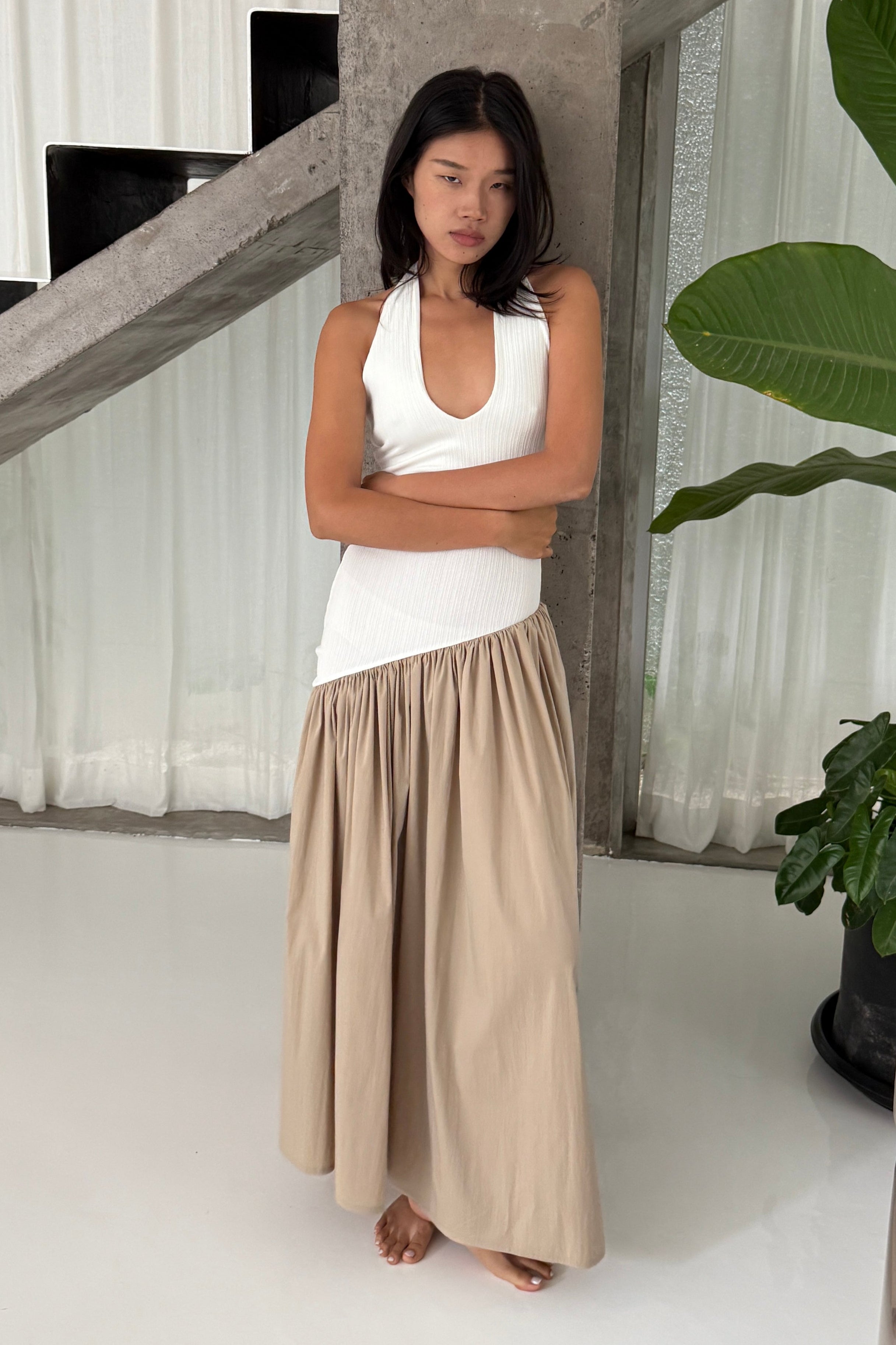 White halter maxi dress with v-neck line and asymmetric artfully gathered beige skirt. Top flatters the figure and skirt adds flow with every movement. Perfect for beach outings and summer soirées.