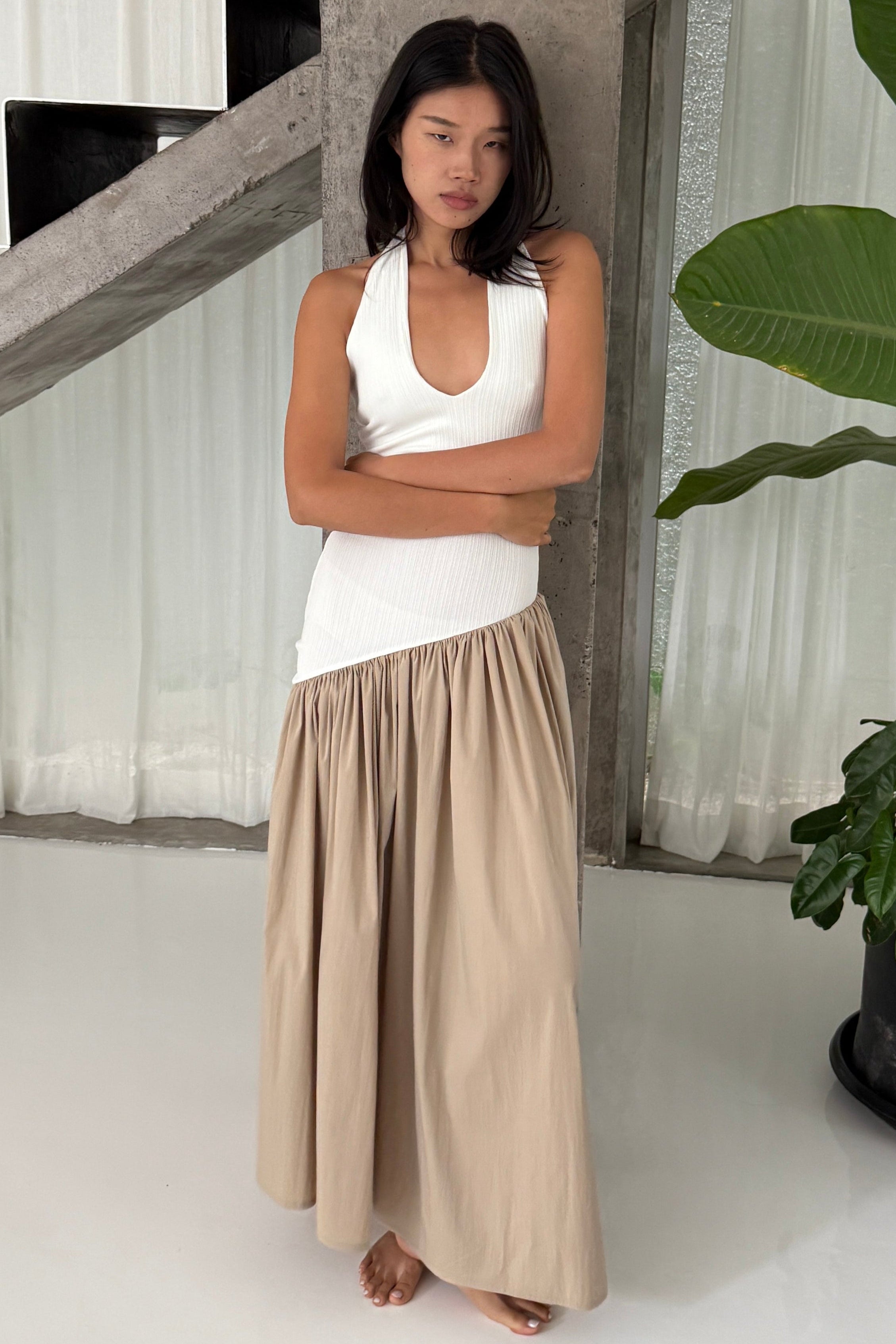 White halter maxi dress with v-neck line and asymmetric artfully gathered beige skirt. Top flatters the figure and skirt adds flow with every movement. Perfect for beach outings and summer soirées.