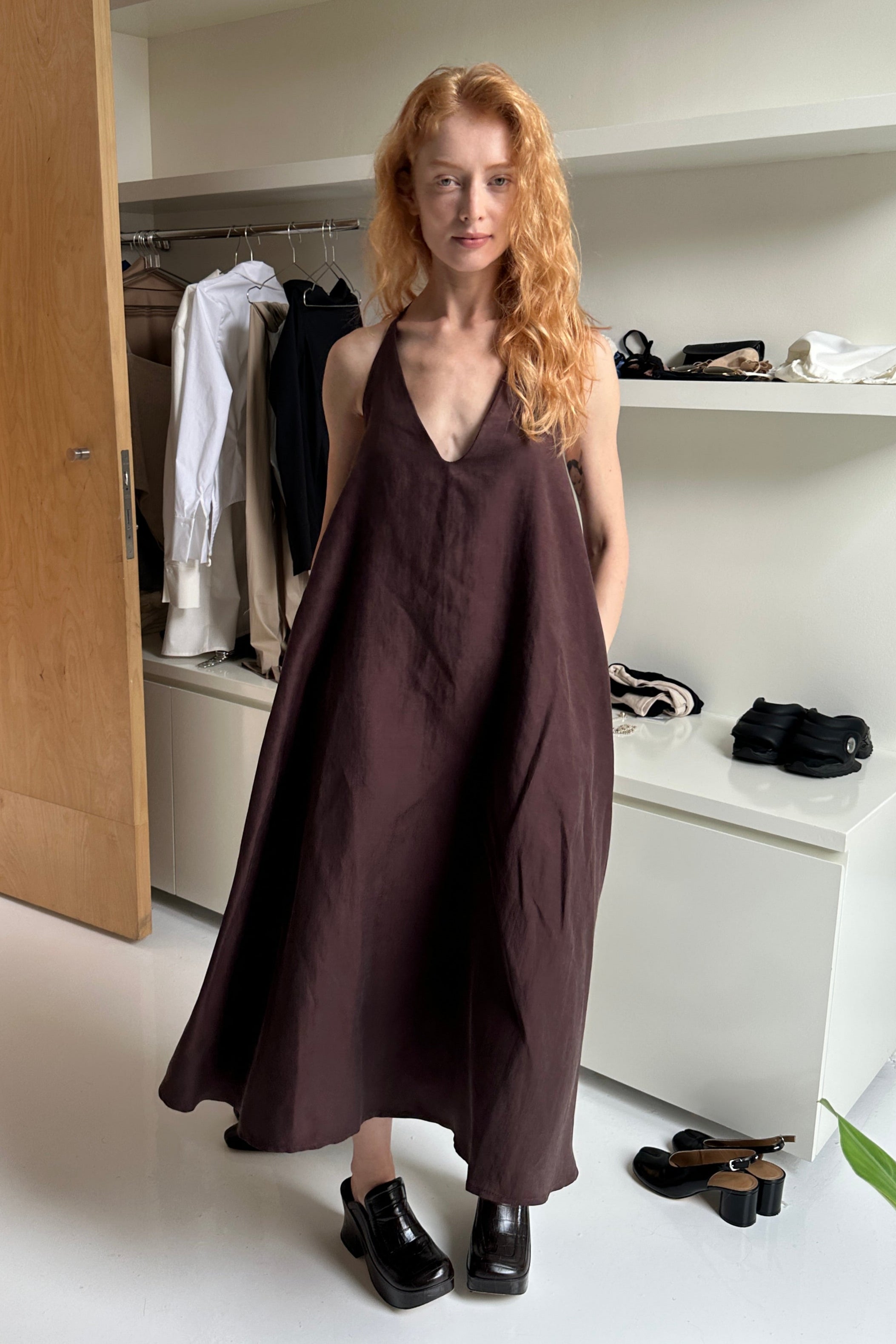 Woman in brown a-line draped dress with a scooped v-neck.