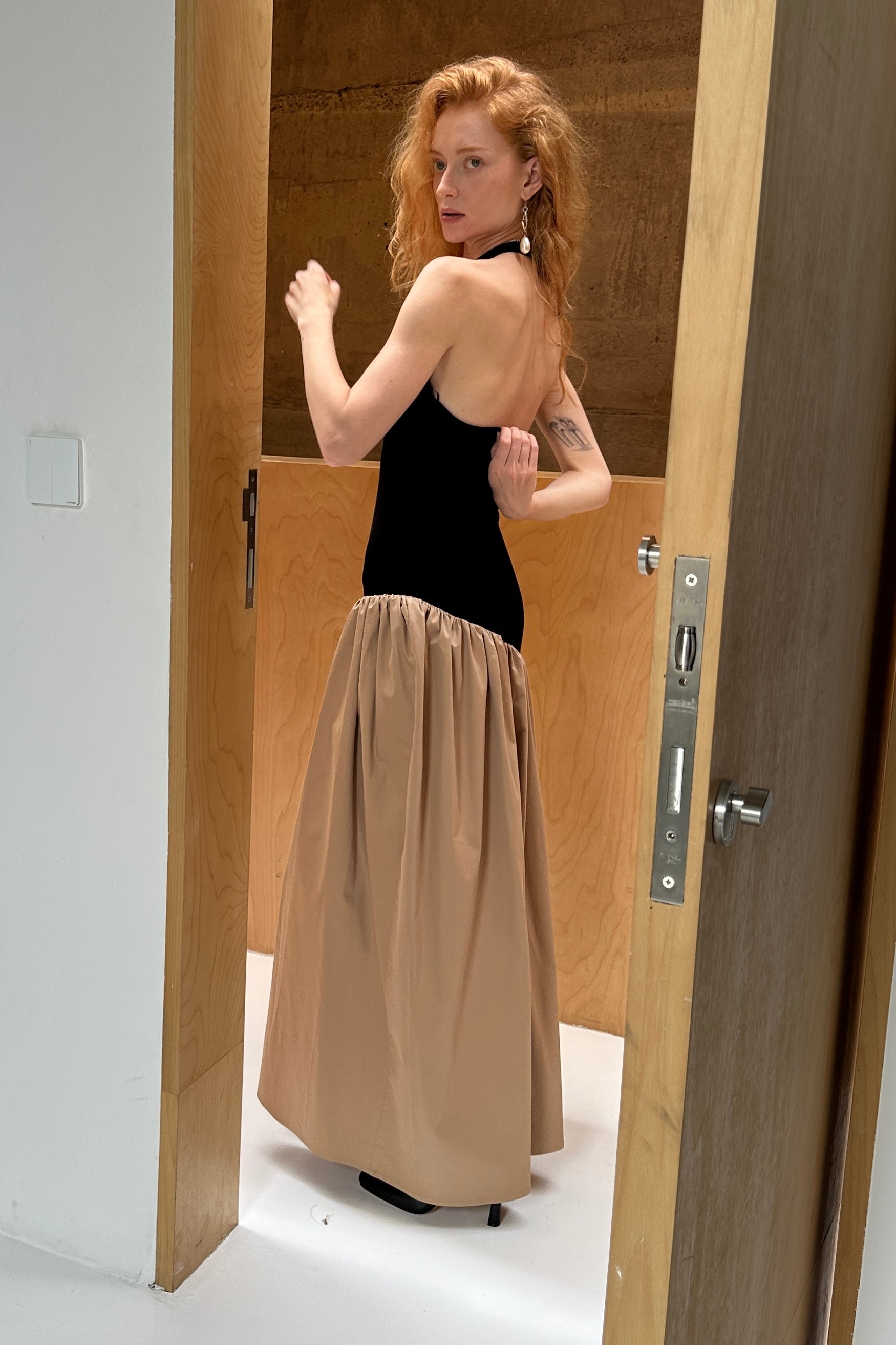 Black halter maxi dress with asymmetric artfully gathered beige skirt. Top flatters the figure and skirt adds flow with every movement. Backless style that accentuates the shoulders. Perfect for beach outings and summer soirées.
