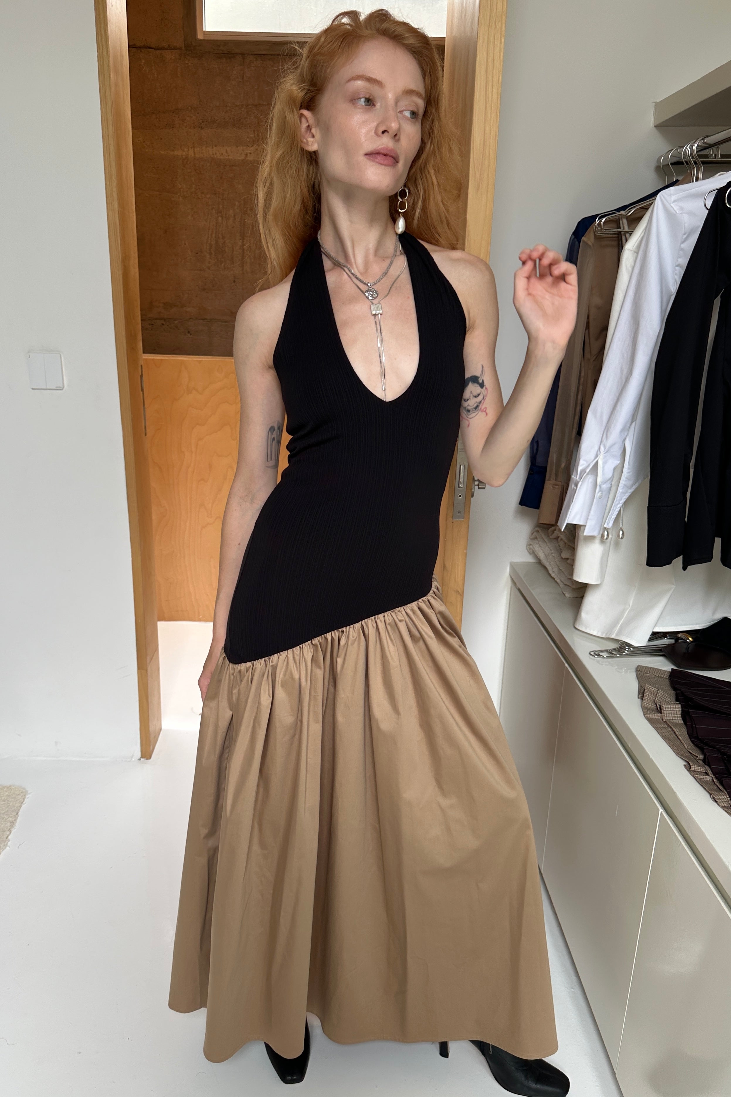 Black halter maxi dress with v-neck line and asymmetric artfully gathered beige skirt. Top flatters the figure and skirt adds flow with every movement. Perfect for beach outings and summer soirées. Styled with two silver necklaces.