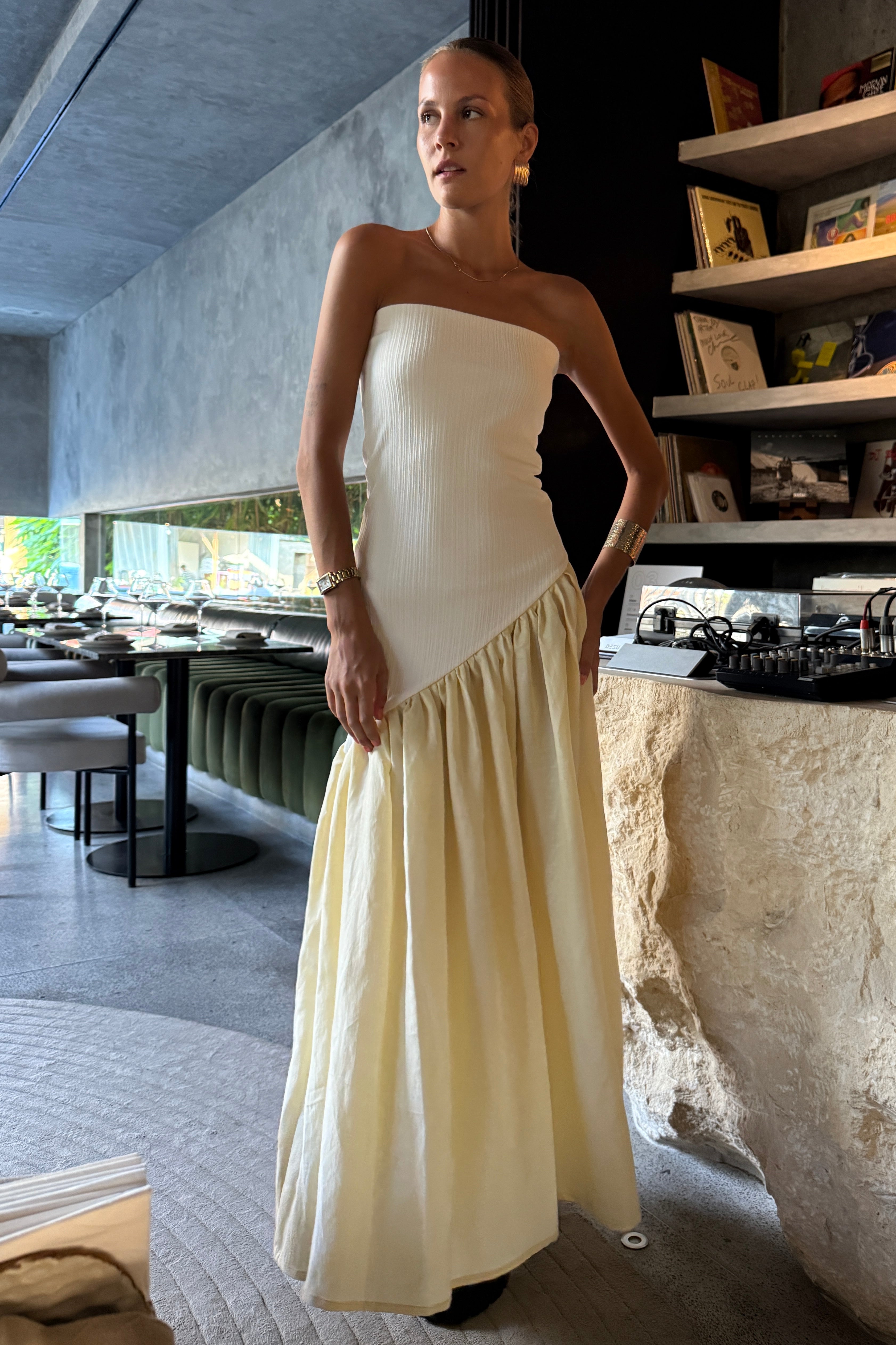 Woman in strapless white maxi dress with asymmetric artfully gathered lemon skirt. Top flatters the figure and skirt adds flow with every movement. Perfect for beach outings and summer soirées.