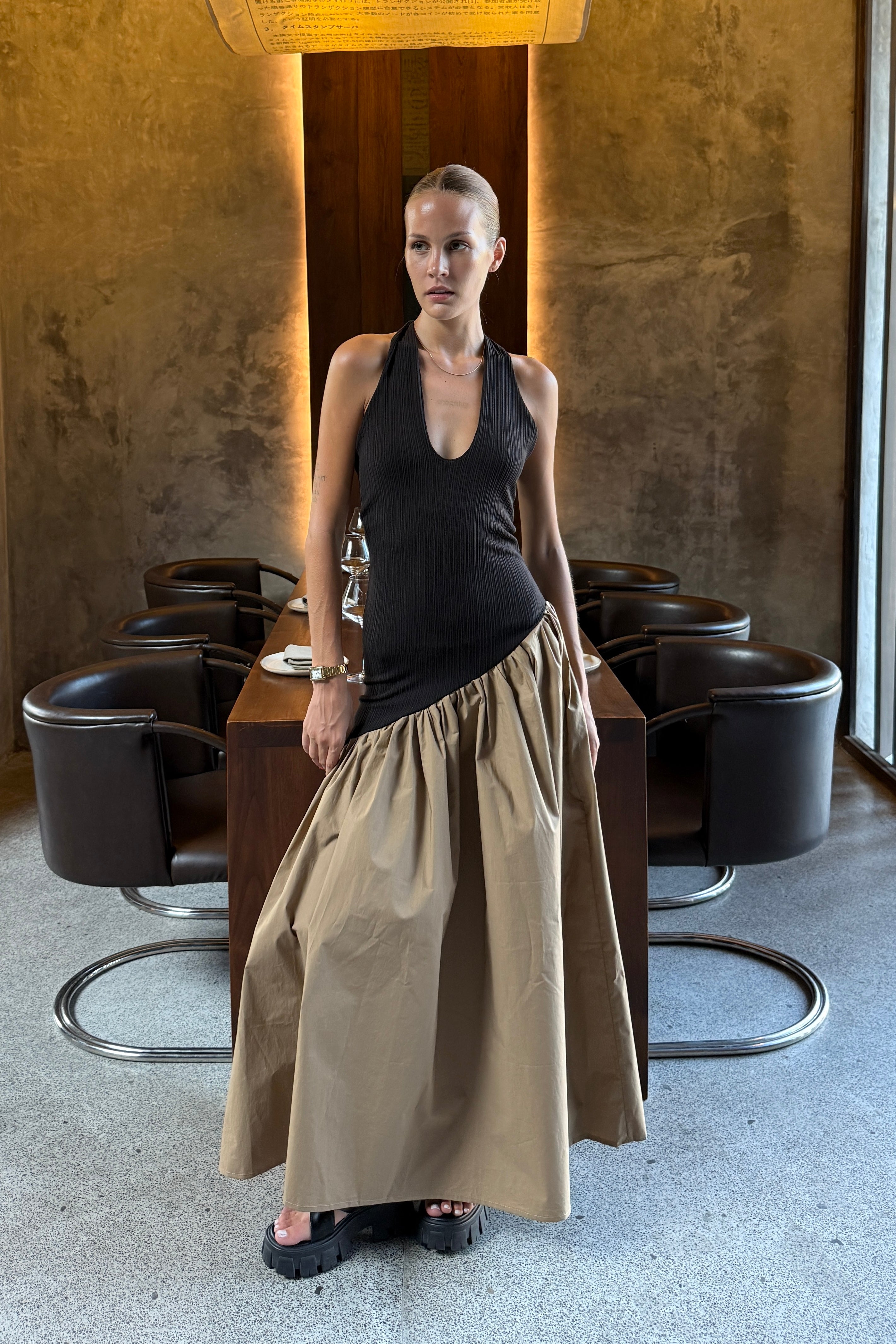 Black halter maxi dress with v-neck line and asymmetric artfully gathered beige skirt. Top flatters the figure and skirt adds flow with every movement. Perfect for beach outings and summer soirées.