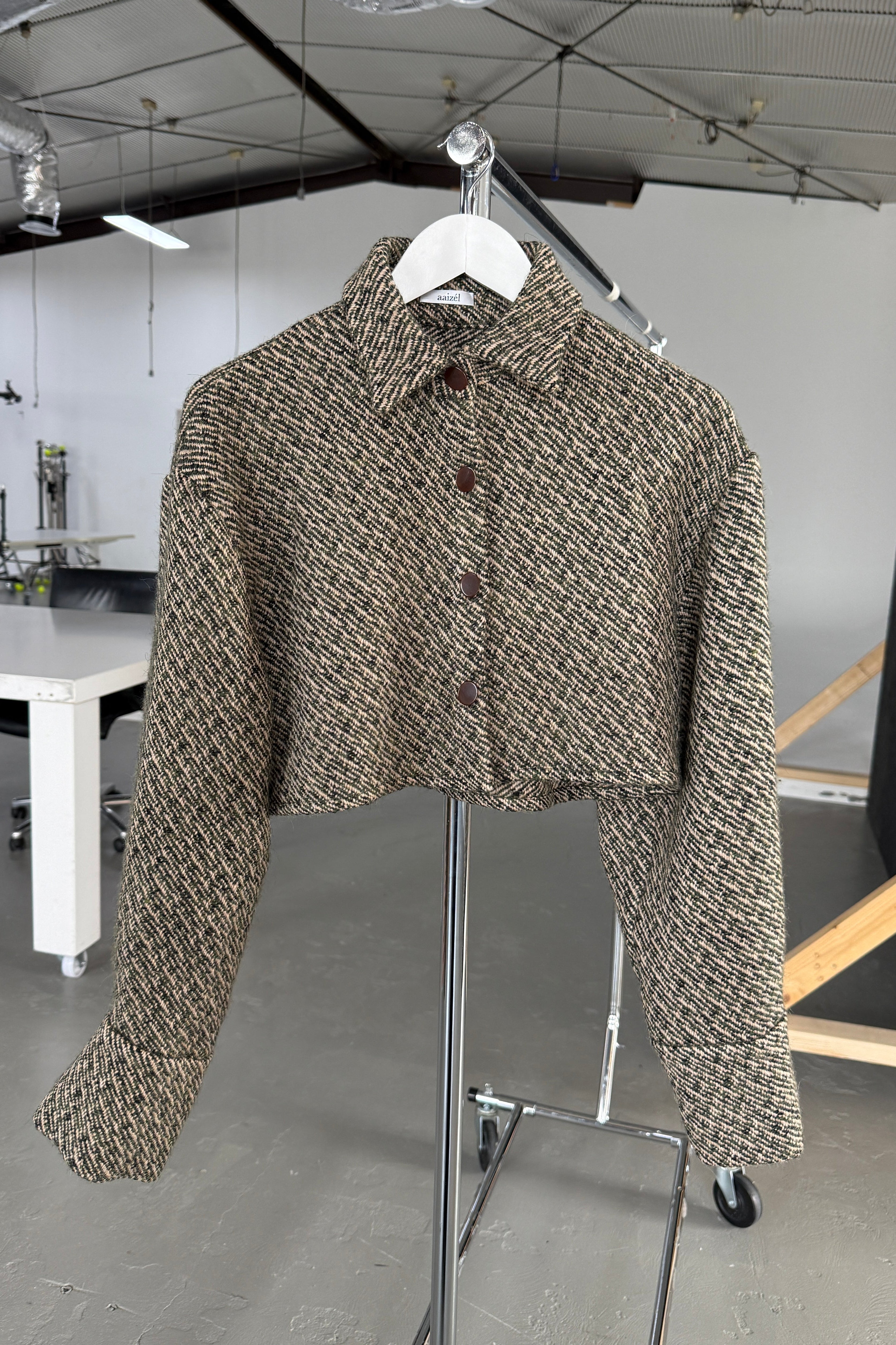 Olive wool bouclé boxy fit cropped jacket with button front closure.