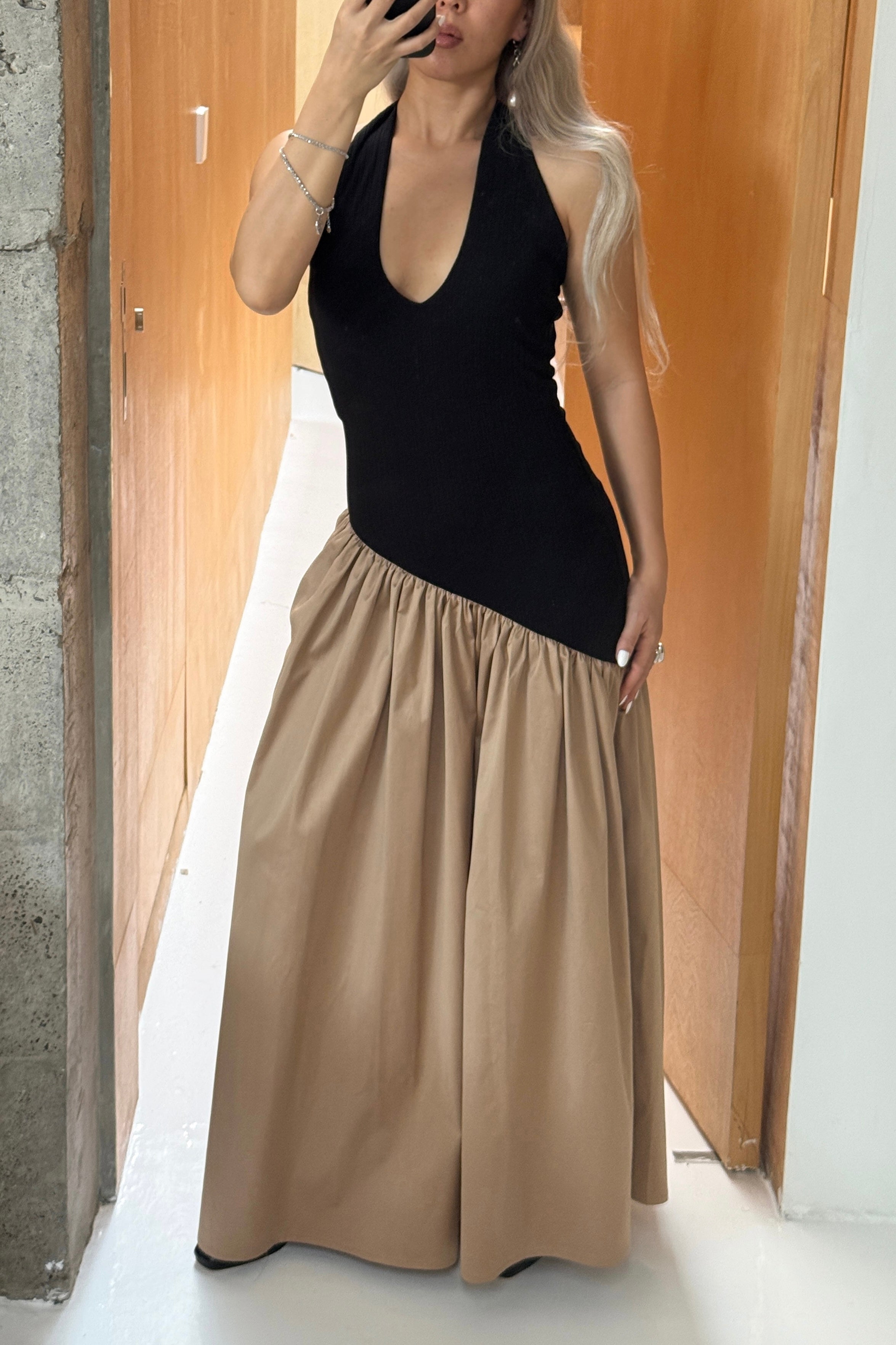 Black halter maxi dress with v-neck line and asymmetric artfully gathered beige skirt. Top flatters the figure and skirt adds flow with every movement. Perfect for beach outings and summer soirées.