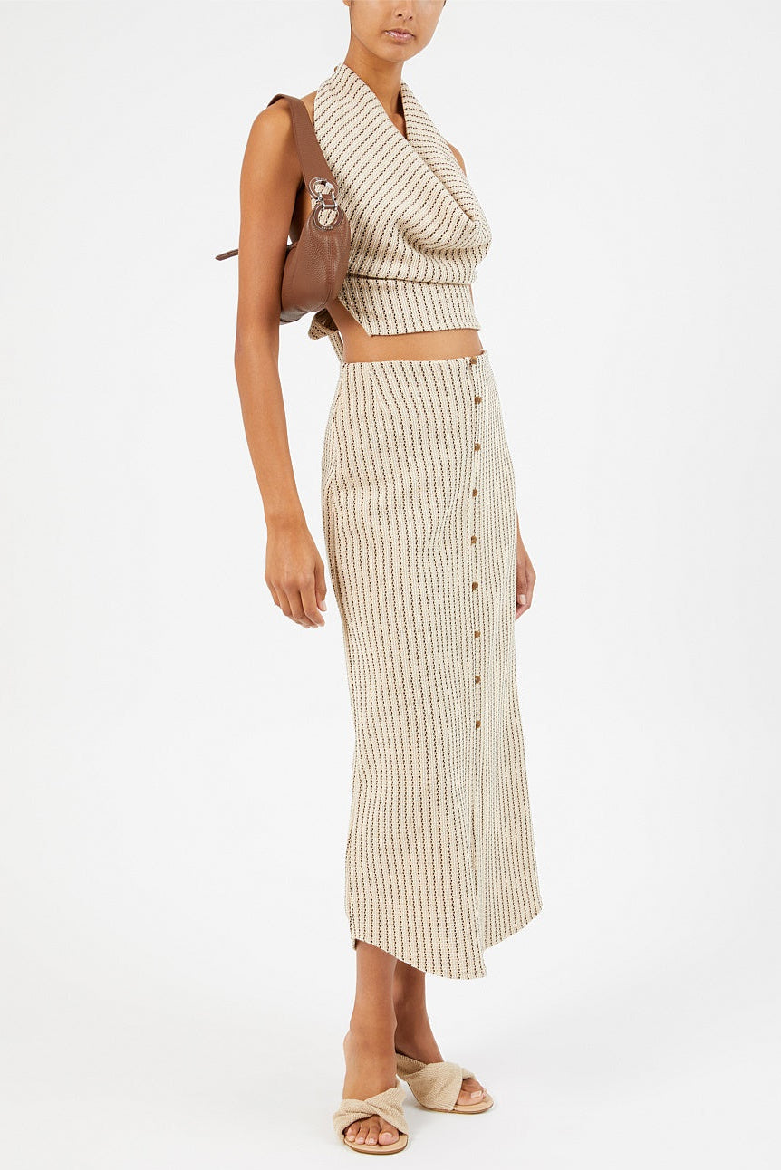 Woman in cropped black beige white striped cowl neck top with tie back. Paired with matching skirt.