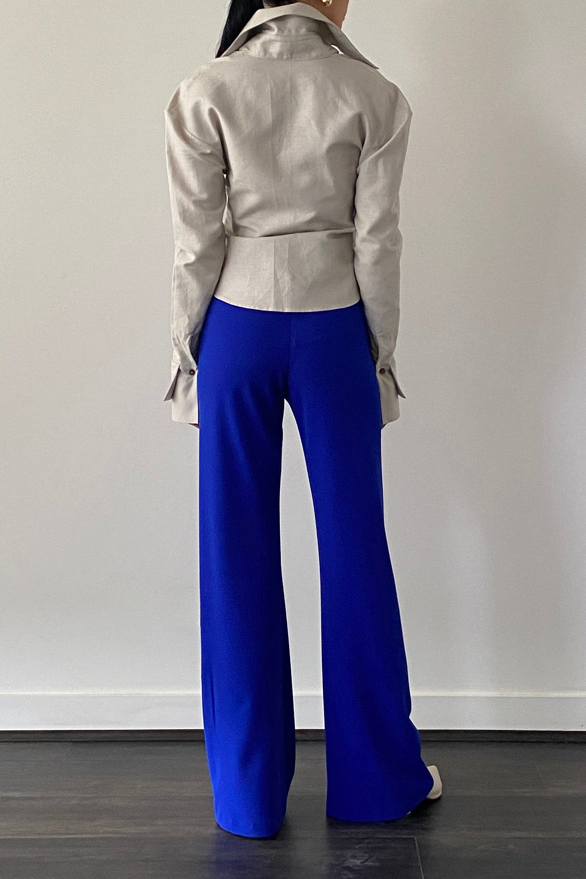 Woman in royal blue high waisted wide leg pant. Paired with beige button down.