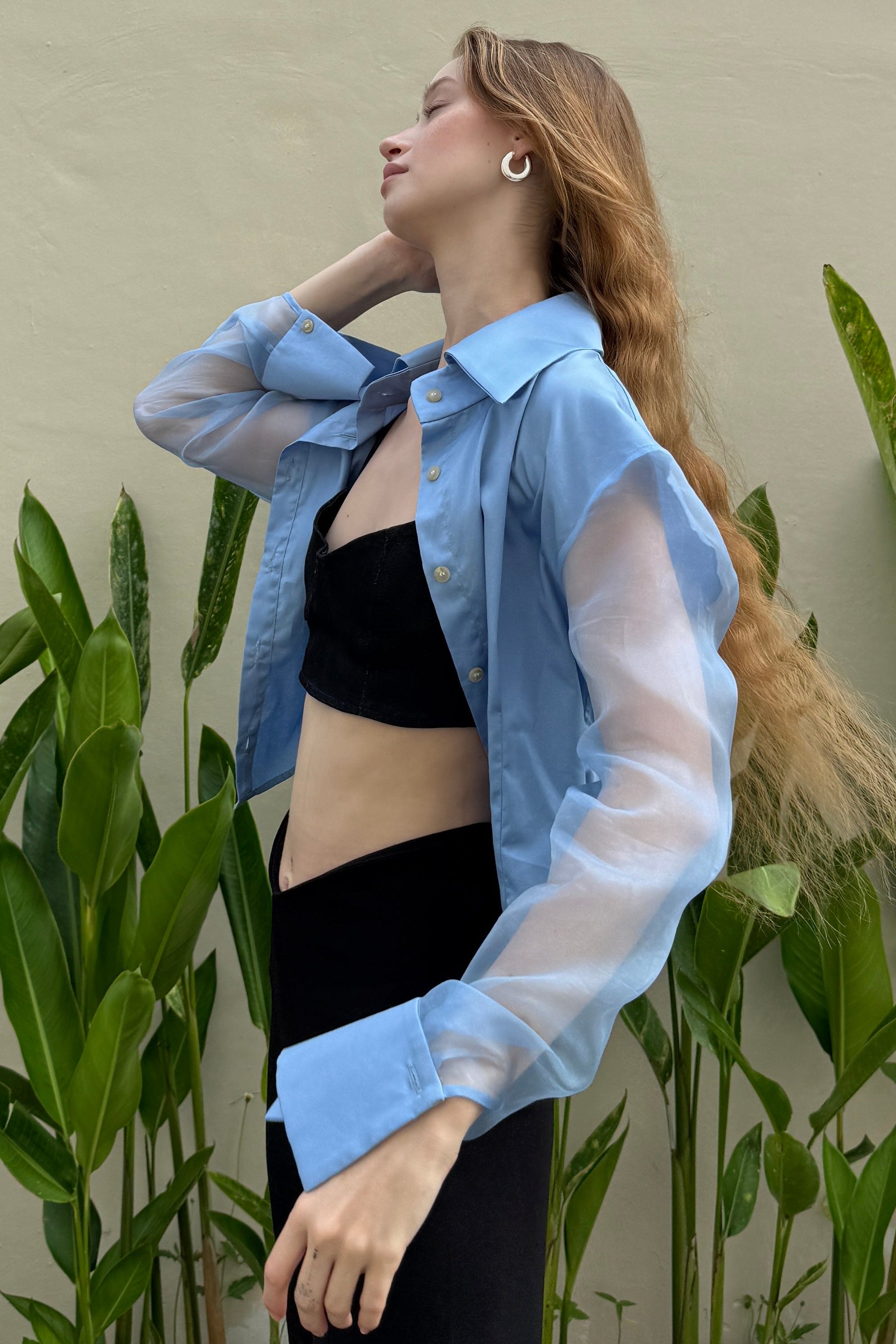 Blue button down shirt with silk organza sheer sleeves. Styled open with a black bralette and trousers. Perfect for the office or summer outings.