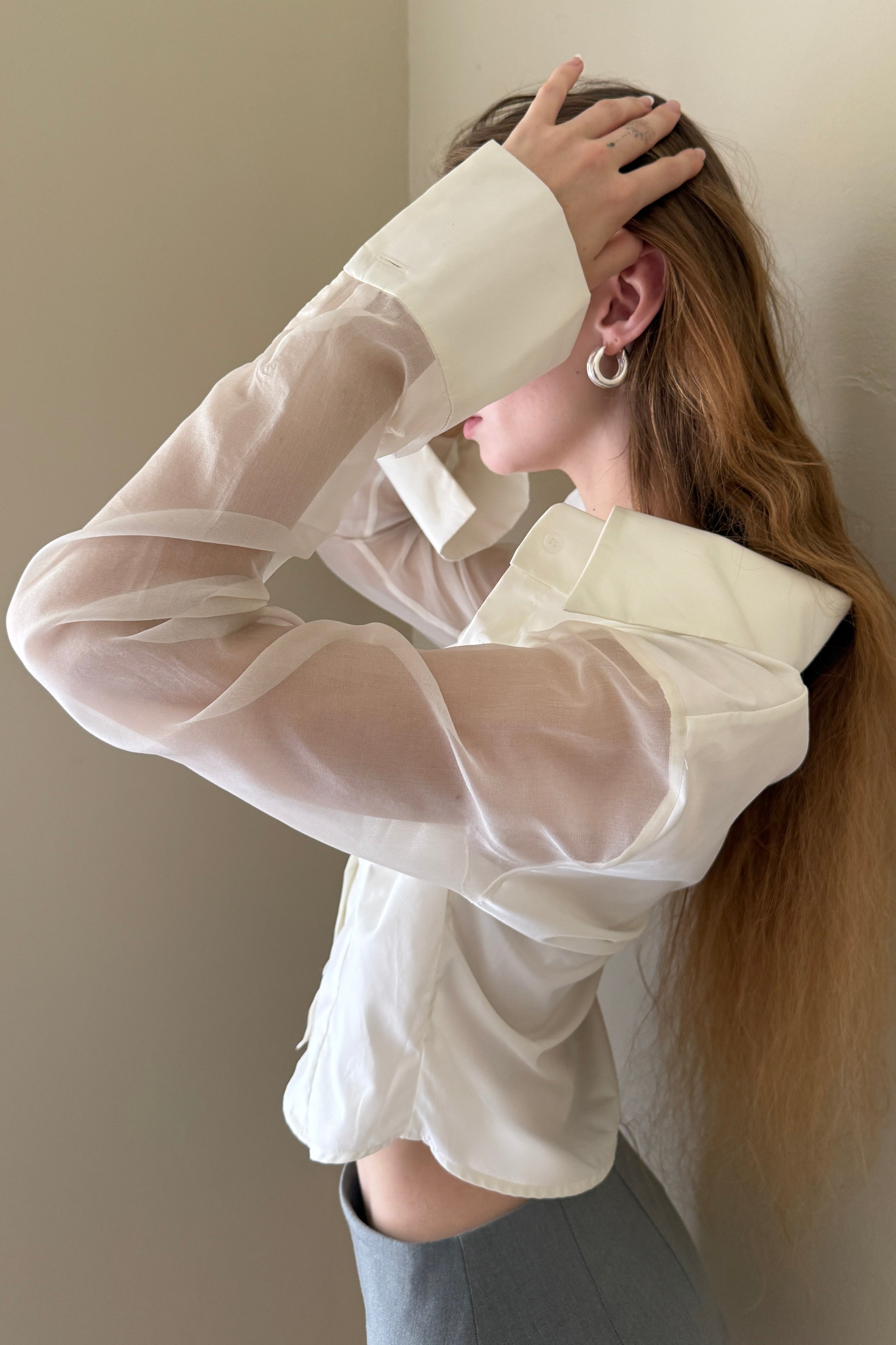 White button down shirt with silk organza sheer sleeves. Styled buttoned up with a grey mini skirt. Perfect for the office or summer outings.